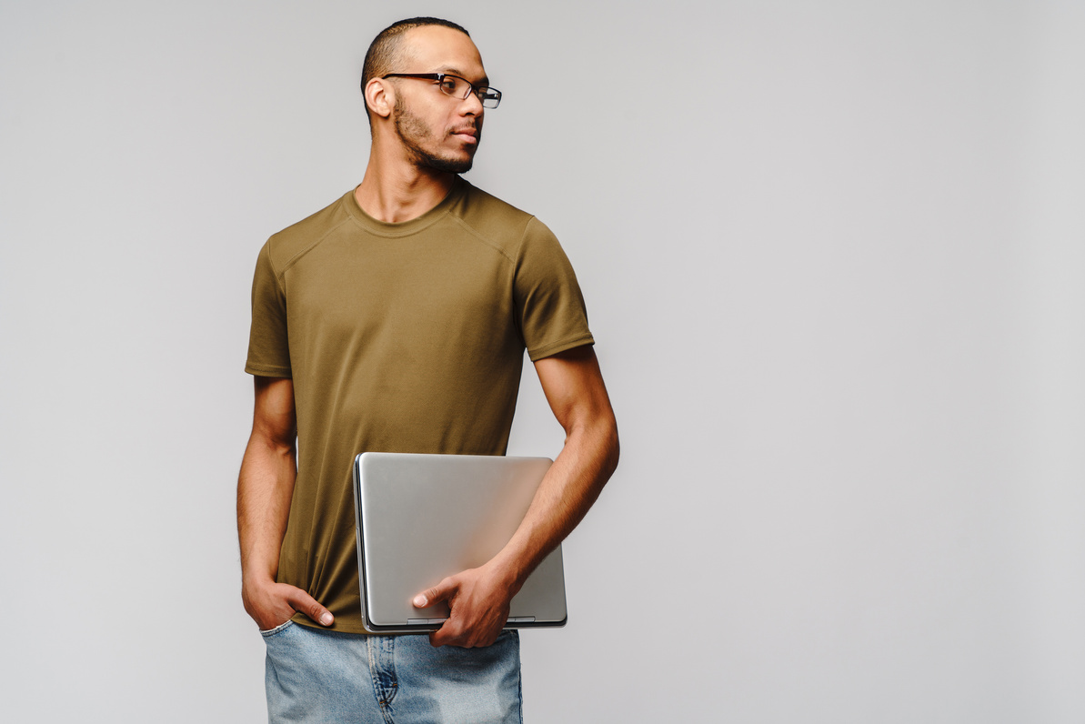 A Young African American Man Wearing Glasses Holding Laptop Pc